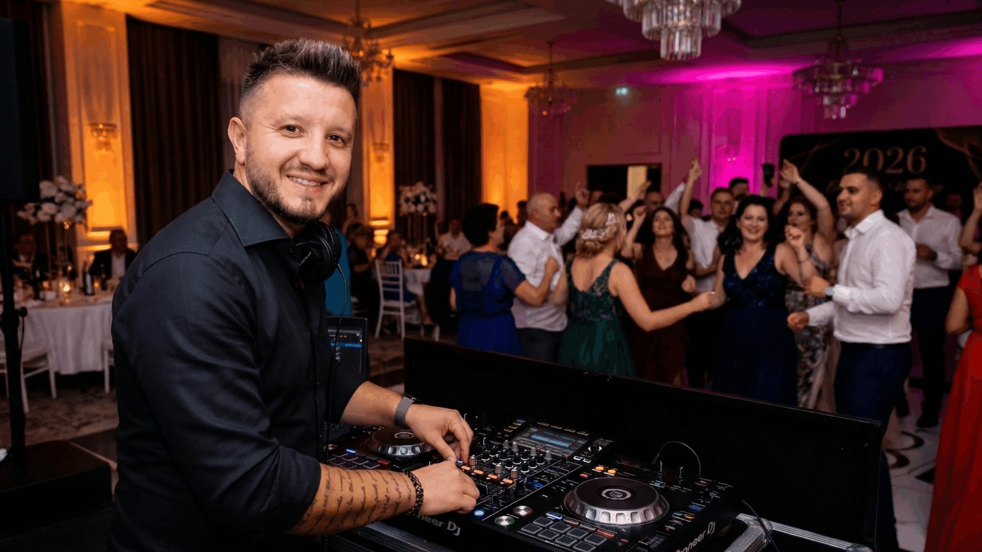 DJ Alex Mitrache la pupitru, mixând un playlist de nuntă 2026 pentru un ring de dans plin de energie.
